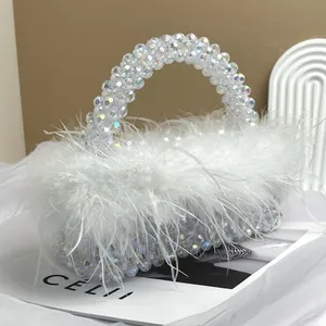 Close-up of elegant handmade beaded handbag with plush white ostrich feathers for party