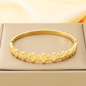Detail eines 18K vergoldeten Kleeblatt-Armreifs mit Zirkonia-Steinen auf Schmuckbox
