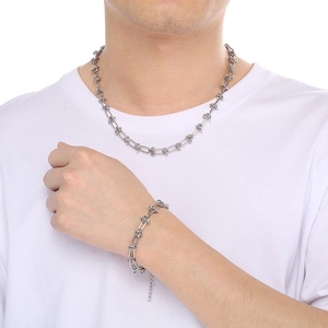 Detail of silver stainless steel knotted chain necklace and bracelet set on a male model