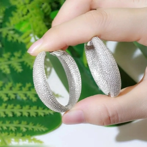 Detailed macro view of large silver-toned hoop earrings with micro-pave crystal inlay