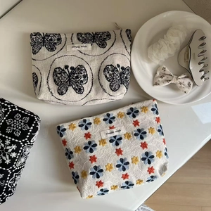 Close-up of cotton linen makeup bags with floral embroidery and simple wish logo label