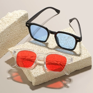 Gafas de sol cuadradas modernas con lentes azules y rojas sobre soportes de piedra
