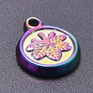 Macro view of rainbow metal pendant with embossed maple leaf detail for jewelry making