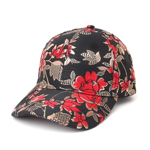 Detailed close-up of vintage black baseball cap with red and gold floral jacquard pattern