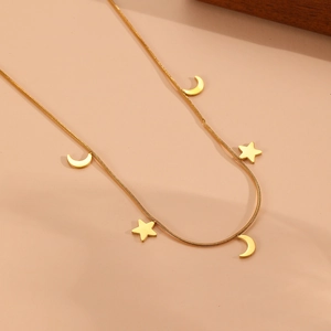 Détail d'un collier chaîne serpent dorée avec d'élégants pendentifs en forme d'étoile