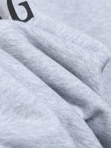 Gros plan sur la texture du tissu en maille gris clair pour ensemble sweat et pantalon