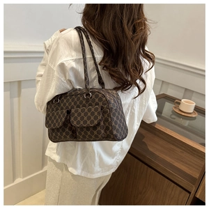 Model view showing the dark brown retro shoulder bag with twin front pockets and vintage pattern