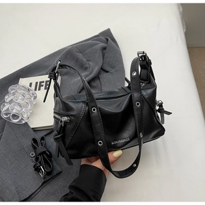 Detail of black large tote bag with metallic rivet handle and premium leather texture