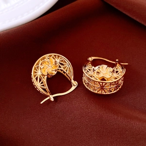Detail shot of 18K gold plated hollow C-shape earrings with floral relief on silk