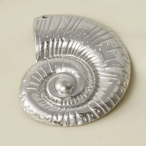 Macro detail of silver stainless steel conch shell pendant with spiral nautilus pattern