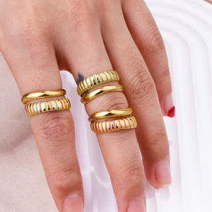 Detail of 18K gold plated rings with colorful enamel stripes and polished finish