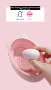 Macro detail of pink silicone cat-ear cleaning bowl scrubbing a beauty sponge