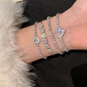 Gros plan de bracelets argentés superposés avec cœurs en zircon et cristaux carrés