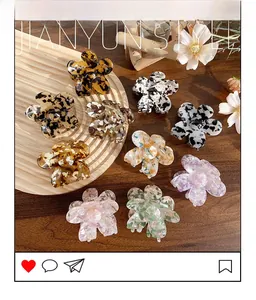 Close-up of various floral claw clips in acetate patterns on a rustic wooden tray