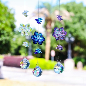 Detailed view of three maple leaf crystal suncatchers in white, blue and violet colors