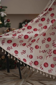 Detail of beige Christmas curtain featuring red candy patterns and elegant tassel edges