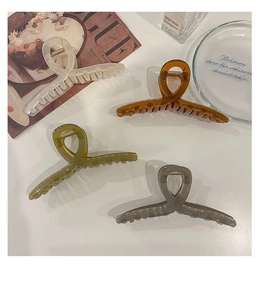 Gros plan de quatre pinces à cheveux en acrylique translucide sur un magazine