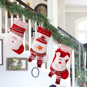 Detailed view of knitted Christmas stockings with 3D Santa, snowman and reindeer on stairs
