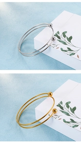 Detailvergleich von goldenen und silbernen Edelstahlarmreifen auf Schmuckständern