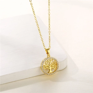 Macro shot of gold tree of life pendant with white cubic zirconia stones on a white surface