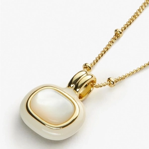 Detail of 18k gold plated necklace with oval white shell pendant and beaded chain