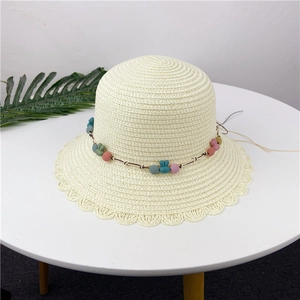 Close-up of summer straw hat weave featuring colorful beads and blue bunny charm detail