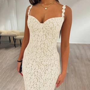 Detail of white lace slip dress with heart neckline and floral straps