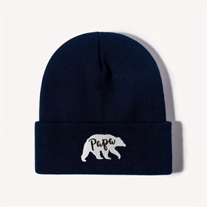 Close-up of navy blue beanie showing white Papa polar bear embroidery and knit texture