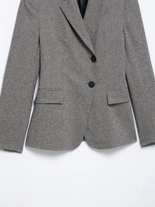 Detail view of grey single-breasted blazer with notch lapels and flap pockets