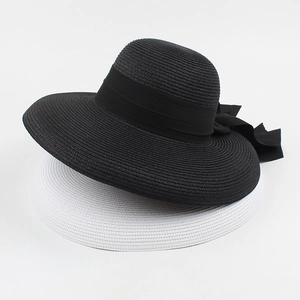 Foldable straw sun hats in black and white with decorative ribbon bows for summer beach