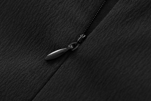 Detail view of the high-quality black fabric texture and matching zipper on the dress