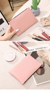 Detail of pink lychee textured PU leather makeup bag with a black zipper closure