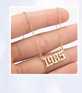 Detail view of gothic style year 1985 pendant on a gold plated stainless steel O-chain