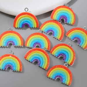 Close-up of glitter rainbow pendants with metal rings for DIY jewelry and accessories