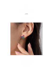 Close-up of three-color floral stud earrings with pink, blue, and green crystals on model