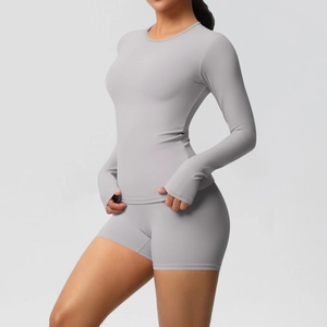Detailed close-up of light gray athletic yoga set with long sleeve top and thumbhole cuffs