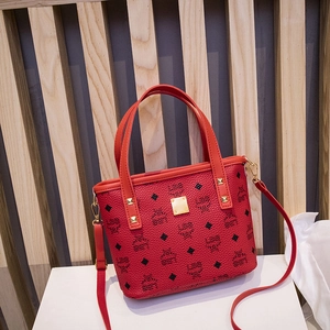 Red monogram bucket bag with gold studs and digital print on white pedestal display