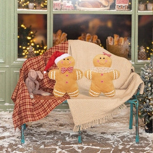 Close-up of plush gingerbread man pillows with Christmas hats and lace collars decoration