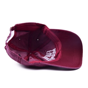 Detailed view of burgundy washed cotton baseball cap with adjustable metal buckle and vents
