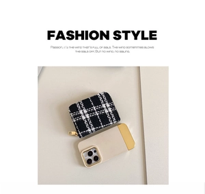 Detail of tweed coin purse featuring black and white houndstooth pattern and gold zipper