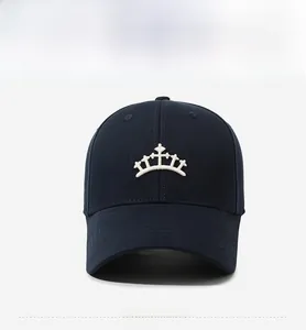 Détails de broderie sur une casquette en coton bleu marine avec un logo couronne blanc