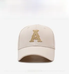 Front view of light beige baseball cap with gold embroidered letter A on canvas fabric