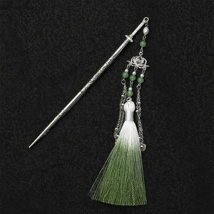 Close-up of lotus pendant hair stick with gradient green tassels and silver metal texture
