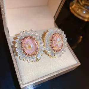 Elegant floral stud earrings with pink oval relief and marquise crystal petals