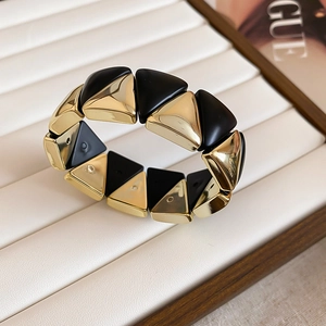 Detail of geometric wide bangle with matte black and polished gold triangles