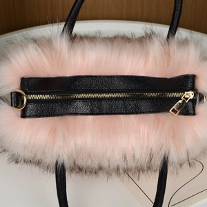 Top view detail of pink faux fur tote bag featuring black leather trim and golden zipper