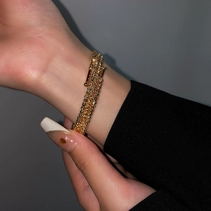 Close-up of luxury multilayer gold beaded bracelet on wrist with elegant metallic finish