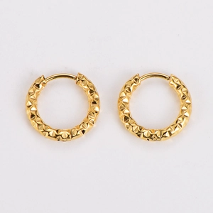 Detailed close-up of golden hoop earrings featuring a unique hammered diamond pattern texture