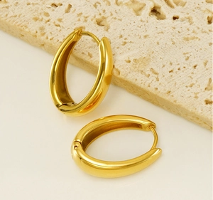 Vue détaillée de boucles d'oreilles gouttes dorées sur un support en pierre texturée