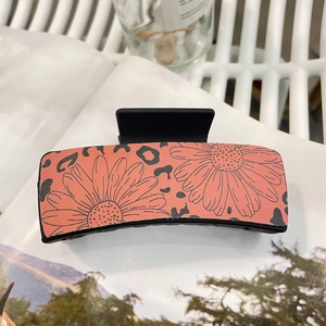 Detail of bohemian rectangle hair claw with coral daisy and leopard print pattern